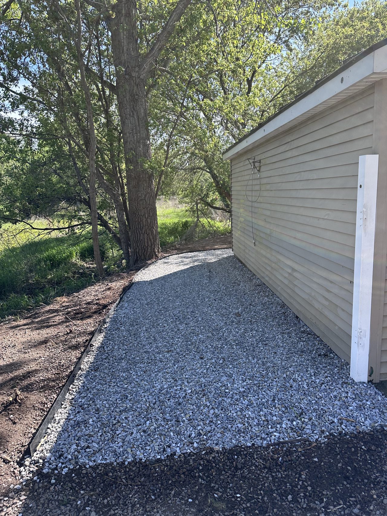 Crushed stone gravel walkway installed along the side of a house