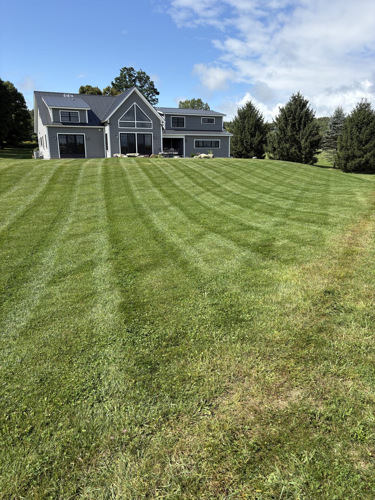 Freshly mowed and striped backyard lawn by L&D Property Maintenance