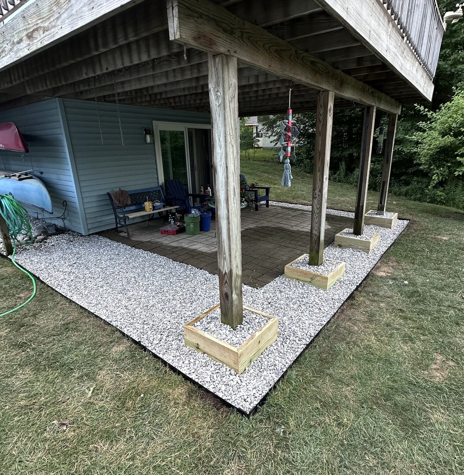White gravel drainage bed installed around deck support posts by L&D Property Maintenance in Essex, VT