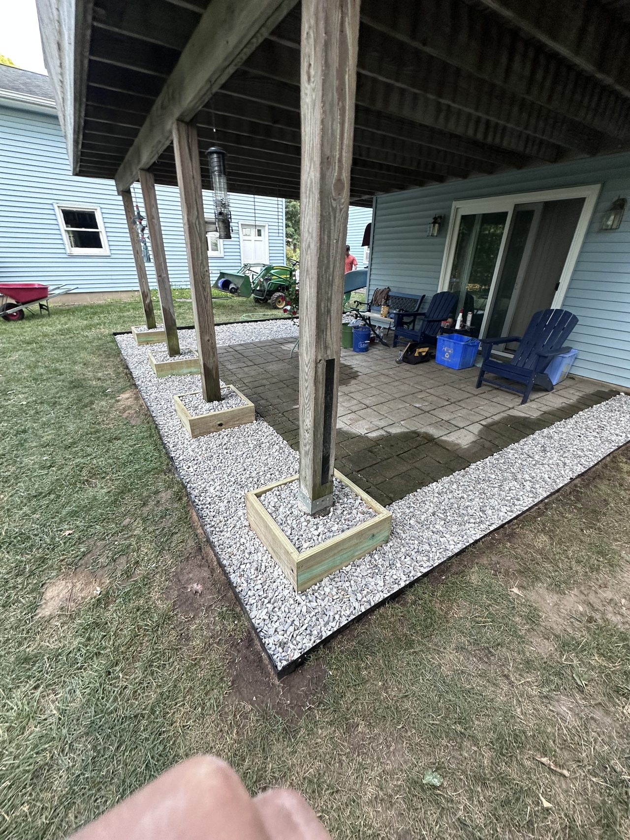 White gravel drainage bed installed around deck support posts